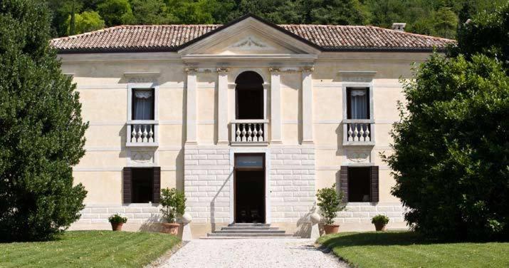 a large white building with a balcony and a door at Villa Barberina in Valdobbiadene