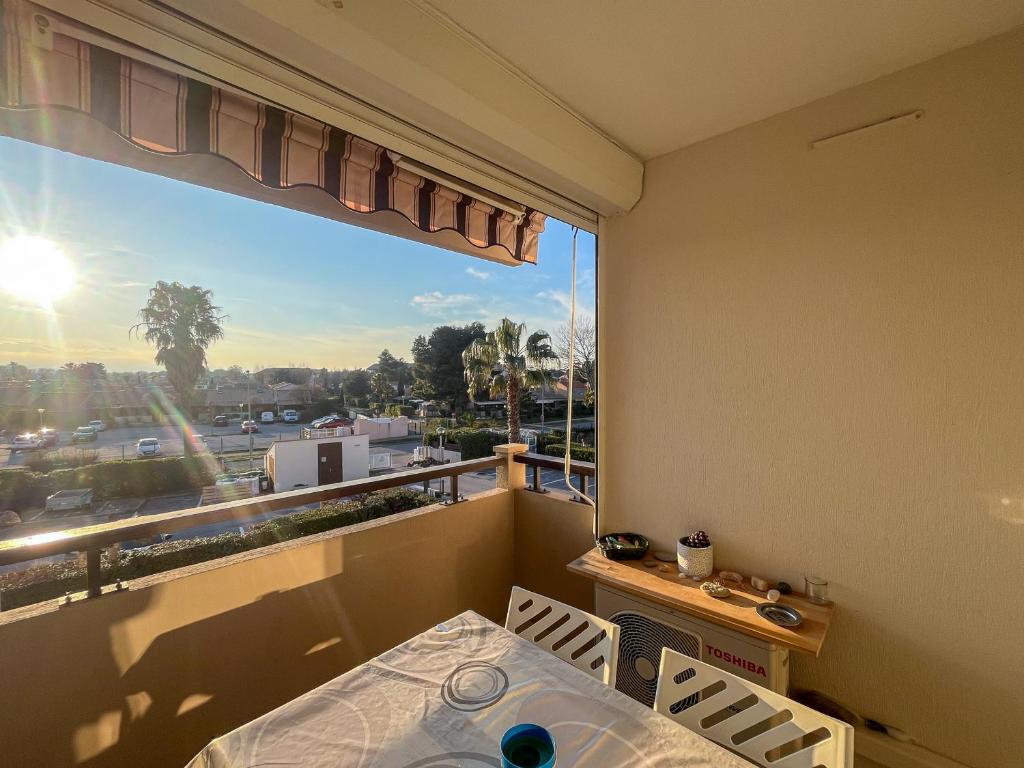 un balcon avec une table et des chaises et une grande fenêtre dans l'établissement Évasion en bord de mer à Saint-Cyprien - FR-1-753-30, à Saint-Cyprien