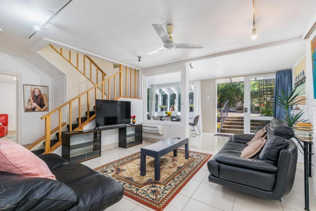 una persona sdraiata su un divano in soggiorno di Charming Garden Guest Suite in Leafy Yarralumla a Yarralumla