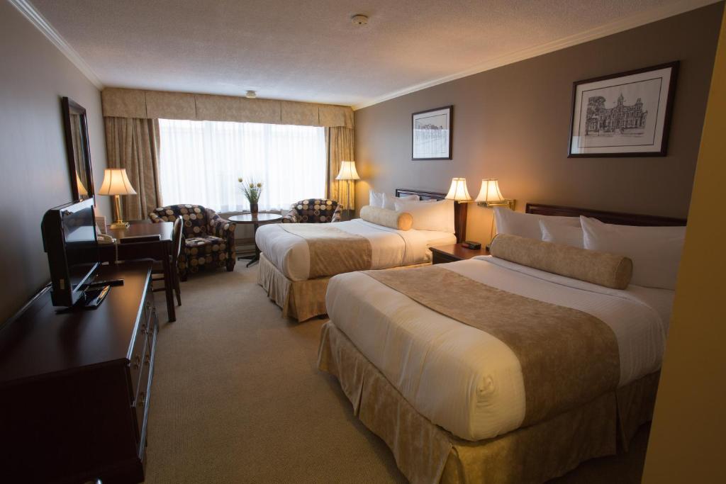 Postel nebo postele na pokoji v ubytování The Fredericton Inn