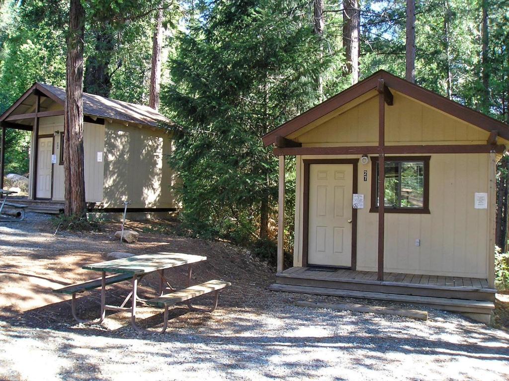 a shed with a picnic table and a bench in front of it at Yosemite Lakes Bunkhouse Cabin 34 in Harden Flat