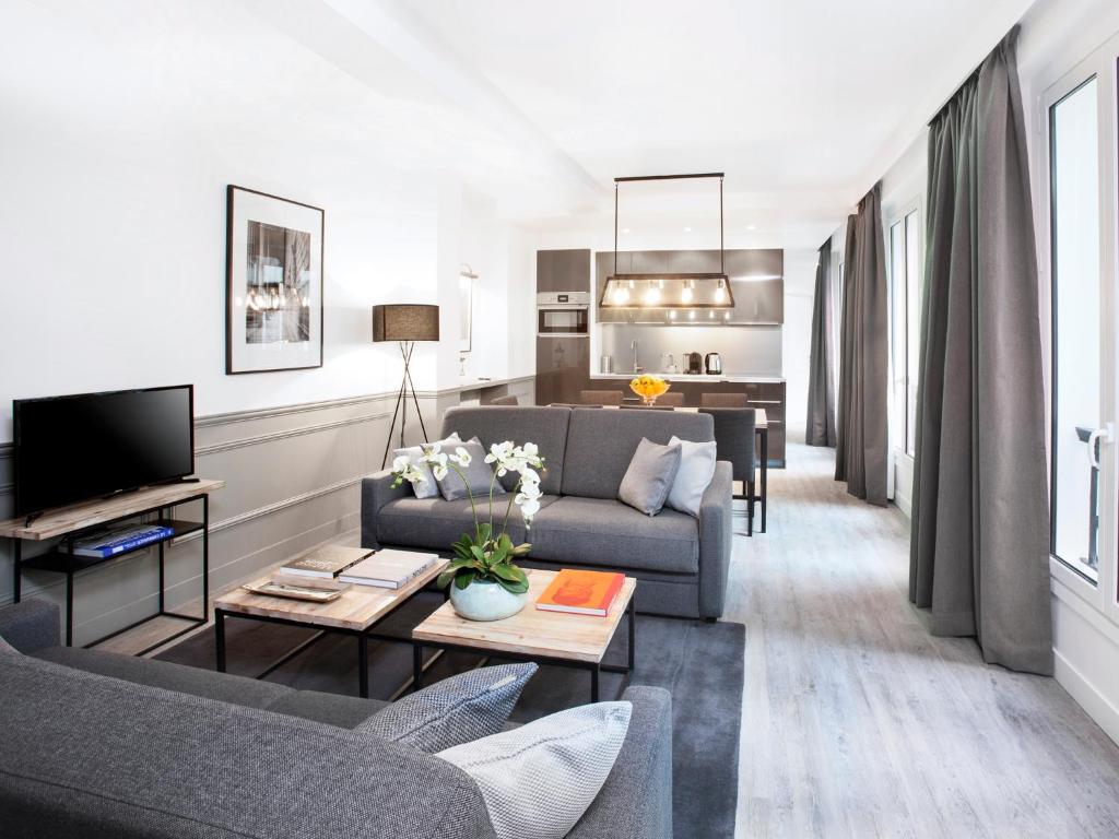 un salon avec un canapé et une télévision dans l'établissement LivinParis - Luxury 3 Bedrooms Le Marais I, à Paris