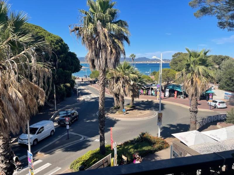 Elle offre une vue sur une rue bordée de palmiers et l'océan. dans l'établissement Magnifique vue mer, à Saint-Aygulf