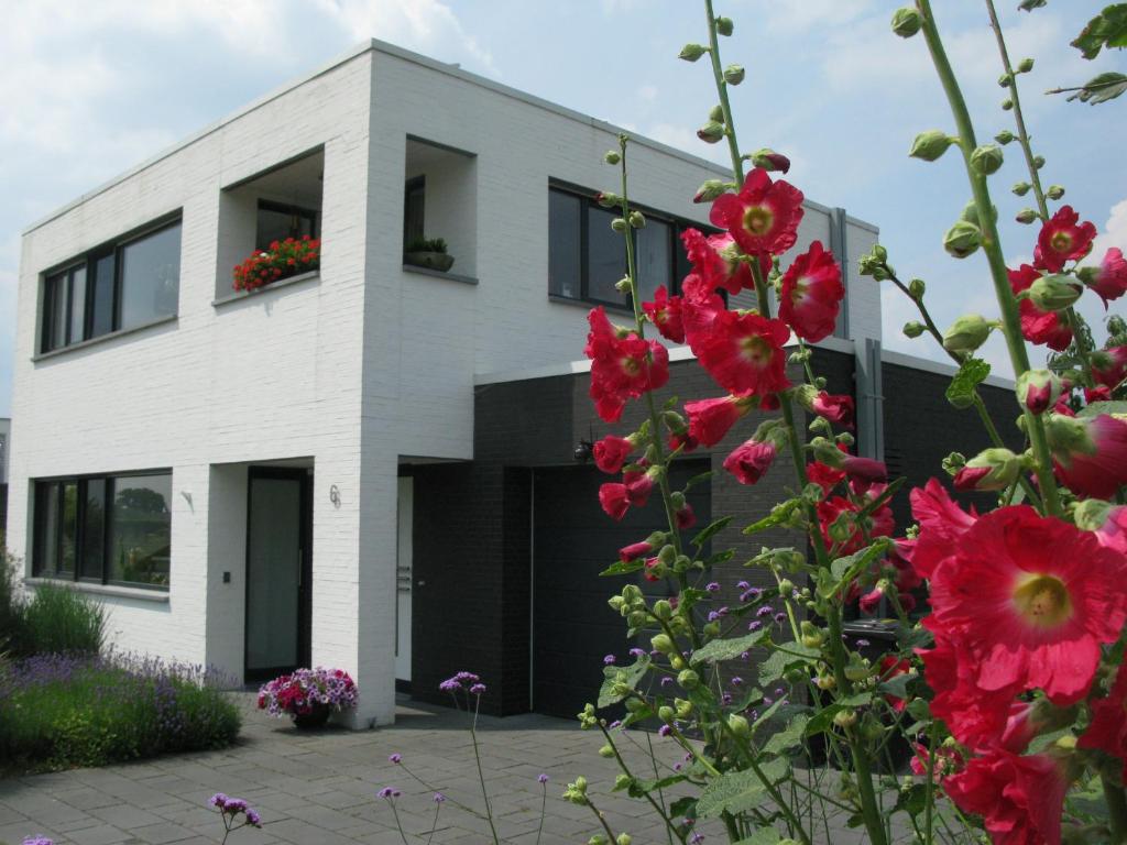 ein weißes Gebäude mit Blumen davor in der Unterkunft B&B De Beverhoek in Roggel