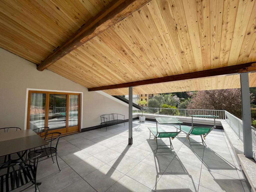a patio with chairs and a wooden ceiling at The Lady of the Lake - Penthouse with Large Terrace and Lake View in Griante Cadenabbia