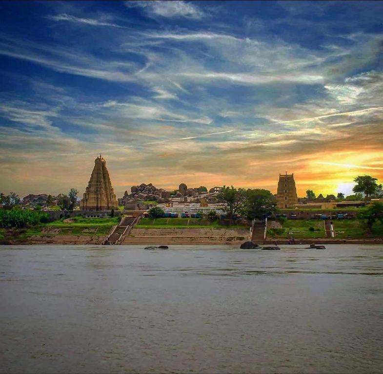 a view of a river with a sunset in the background at Mamatha Guest inn in Hampi