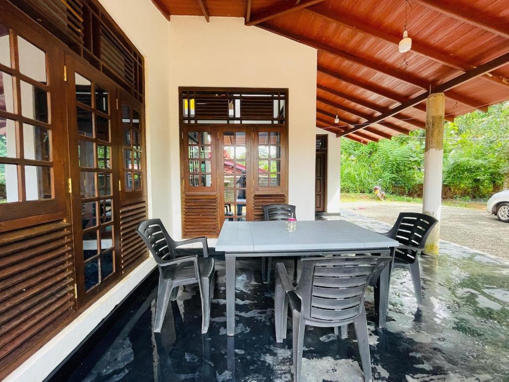 a dining table and chairs on a patio at Mandara Villa Hiriketiya in Dickwella