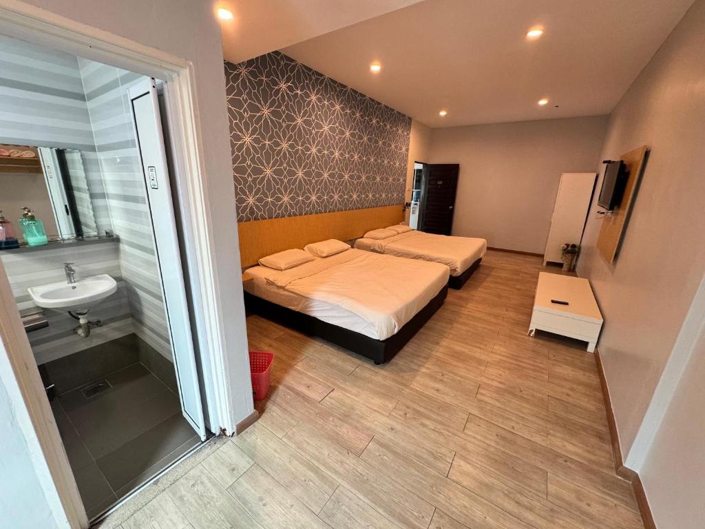a bedroom with a bed and a bathroom with a sink at Tropical villa in Kuantan