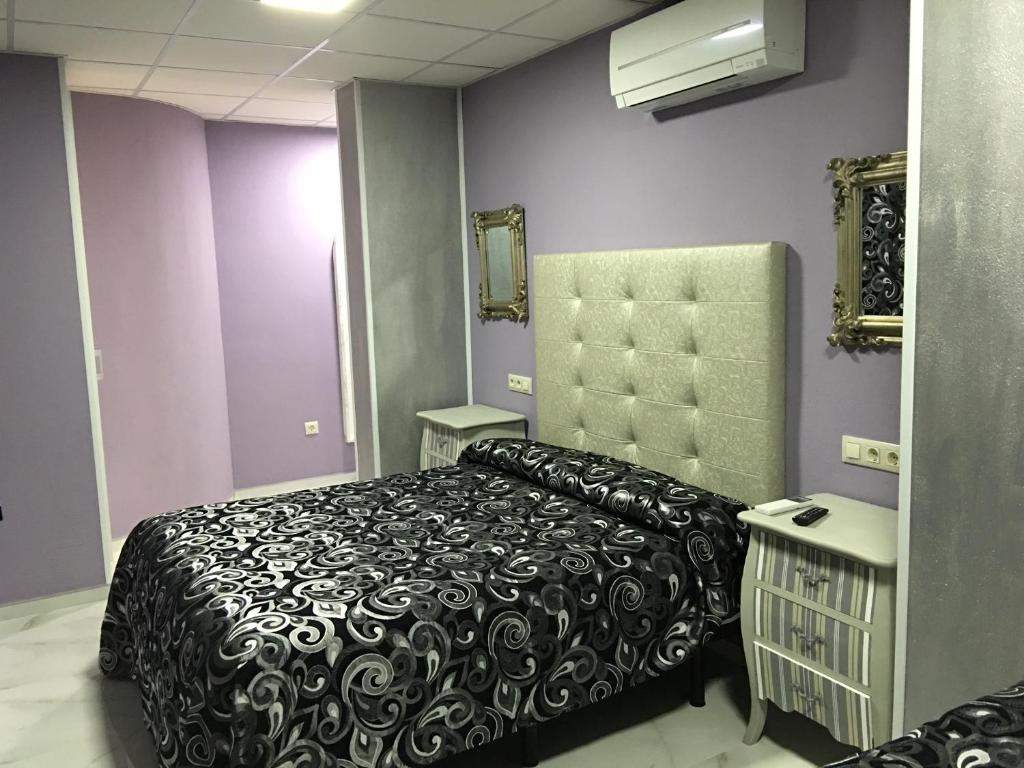 1 dormitorio con 1 cama en blanco y negro y paredes moradas en Just Style El Mañico, en Peñíscola