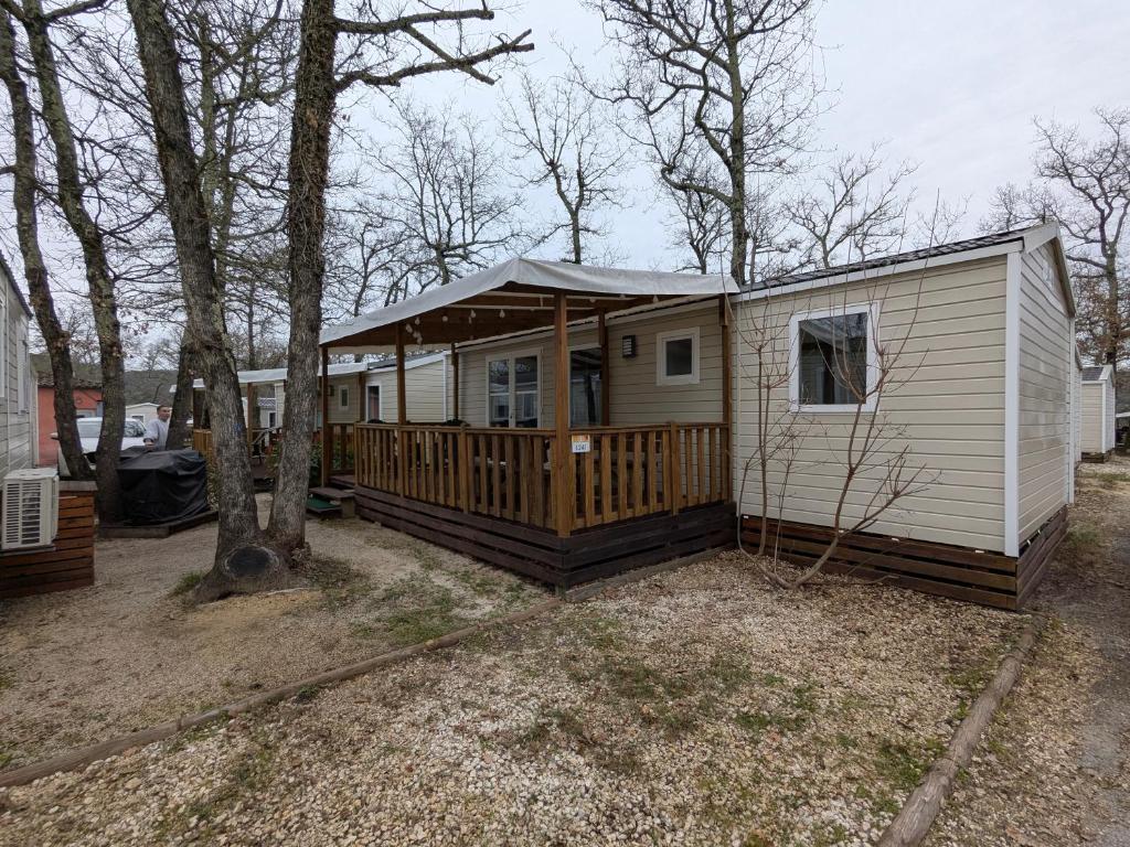 un mobil-home avec un porche et une terrasse dans l'établissement ARDECHE, mobil home 6 personnes climatisé, à Lagorce