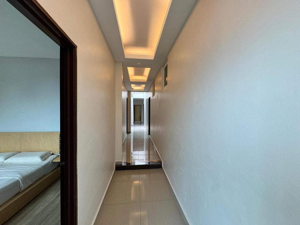 a bedroom with a bed and a hallway with a mirror at Tropical villa in Kuantan