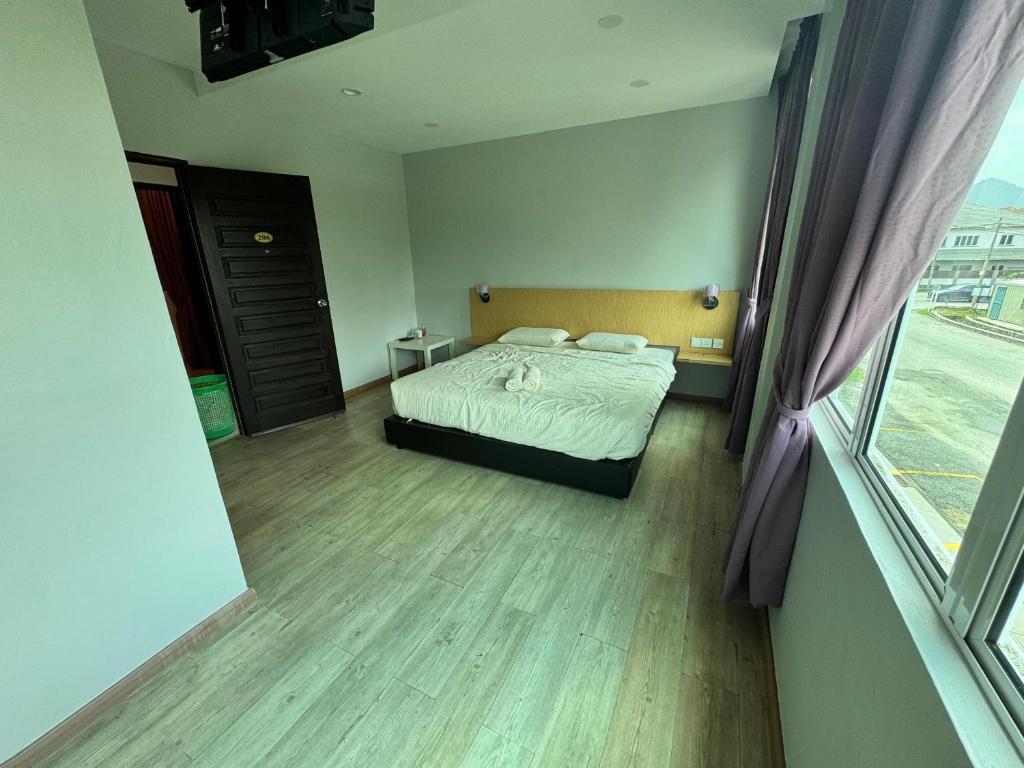 a bedroom with a bed and a large window at Tropical villa in Kuantan