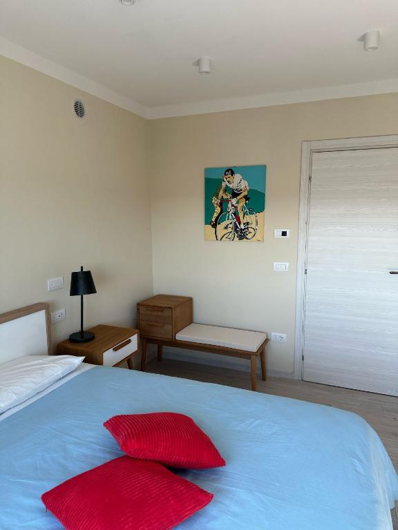 a bedroom with a bed with red pillows on it at Il Corridore - Locanda Bistrò in Felegara