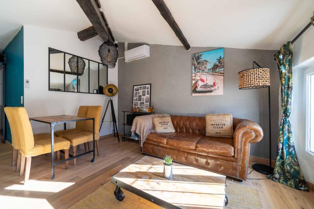 a living room with a couch and a table at Sun dreams, centre ville historique, 10 minutes de Cannes in Vallauris