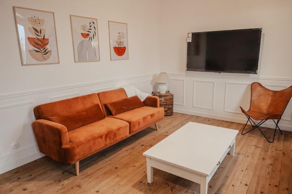 ein Wohnzimmer mit Sofa und Flachbildfernseher in der Unterkunft Maison en bord de Dordogne in Bergerac