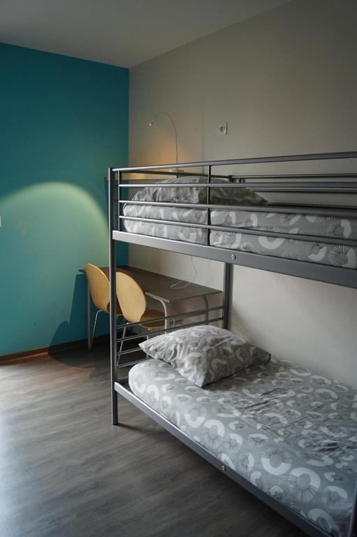 Cette chambre comprend 3 lits superposés et une chaise. dans l'établissement Centre International de Séjour - MJC, à Lézignan-Corbières