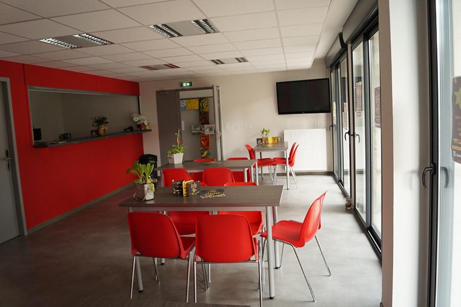 a conference room with red chairs and a table at Centre International de Séjour - MJC in Lézignan-Corbières