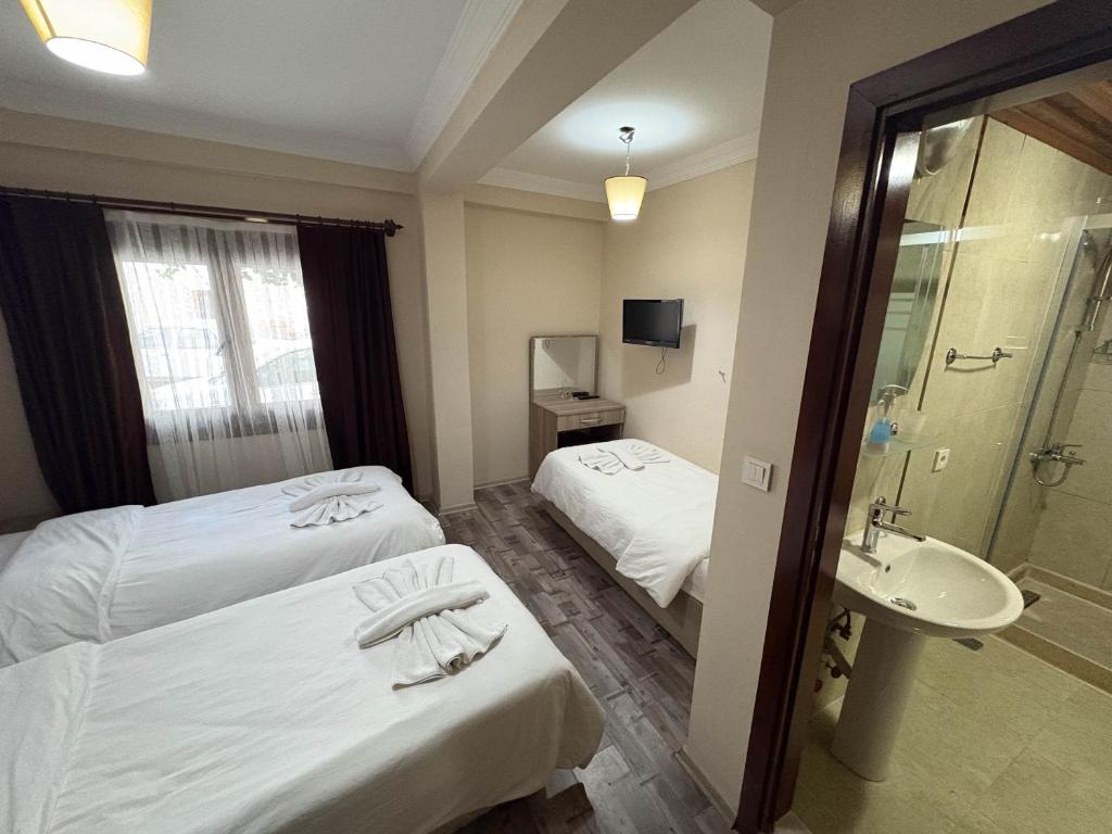 a hotel room with two beds and a sink at Akay Hotel in Selcuk