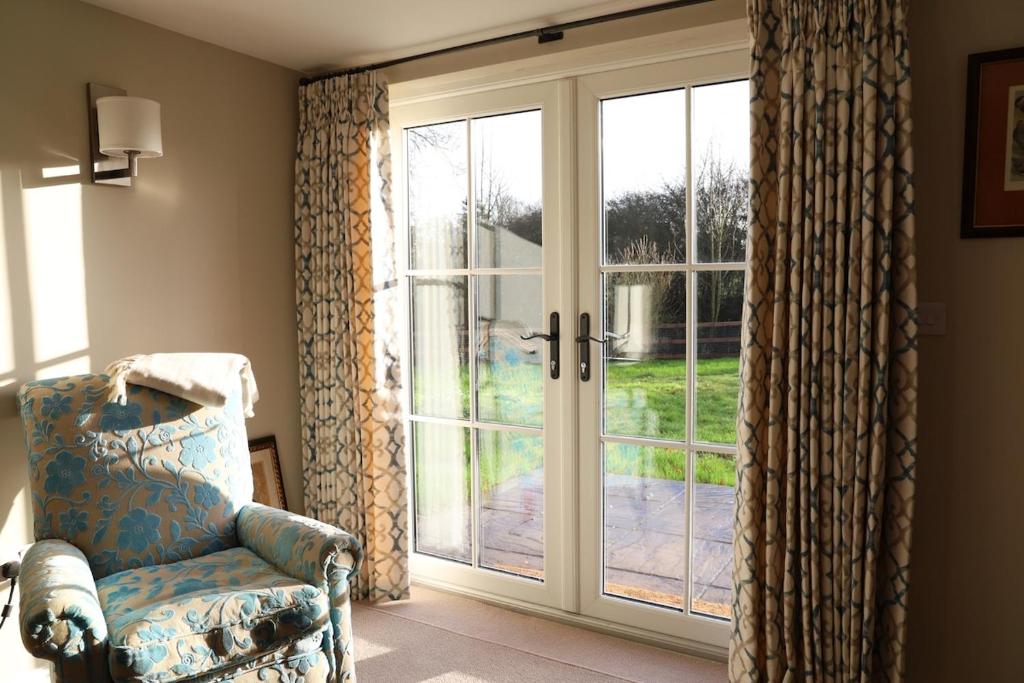 a room with a sliding glass door with a chair at Beautifully refurbished 3 bedroom cottage in Ashdon