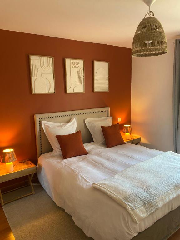 a bedroom with a large white bed with two pillows at La Villa Saint Val in Saint-Valery-sur-Somme