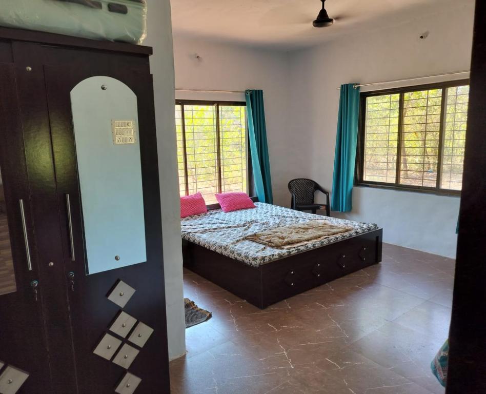 a bedroom with a bed with pink pillows on it at Jungle home stay in Devrukh