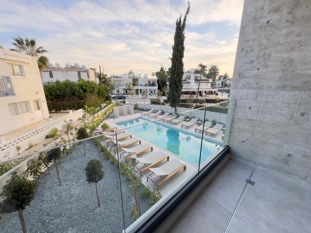 una vista dall'alto di una piscina con sedie a sdraio di Malberry Park 104 - Modern Apt with Shared Heated Pool, Sauna, Gym, Jacuzzi a Paphos