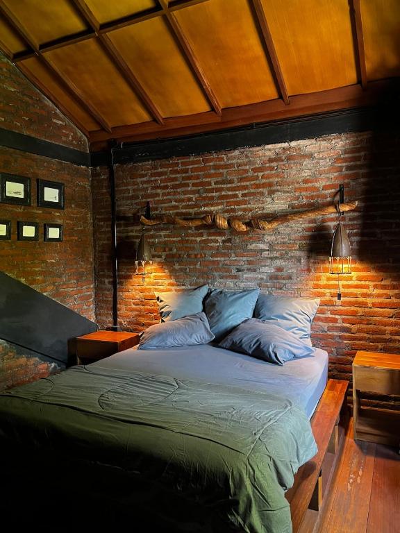 a bed in a room with a brick wall at 1 BR Cozy Apartment in center of Seminyak in Seminyak
