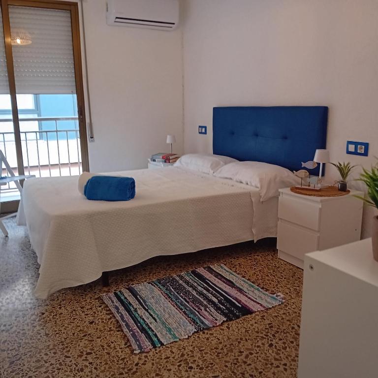 a bedroom with a large bed with a blue headboard at María PLAYA BRISA NG in Peniscola