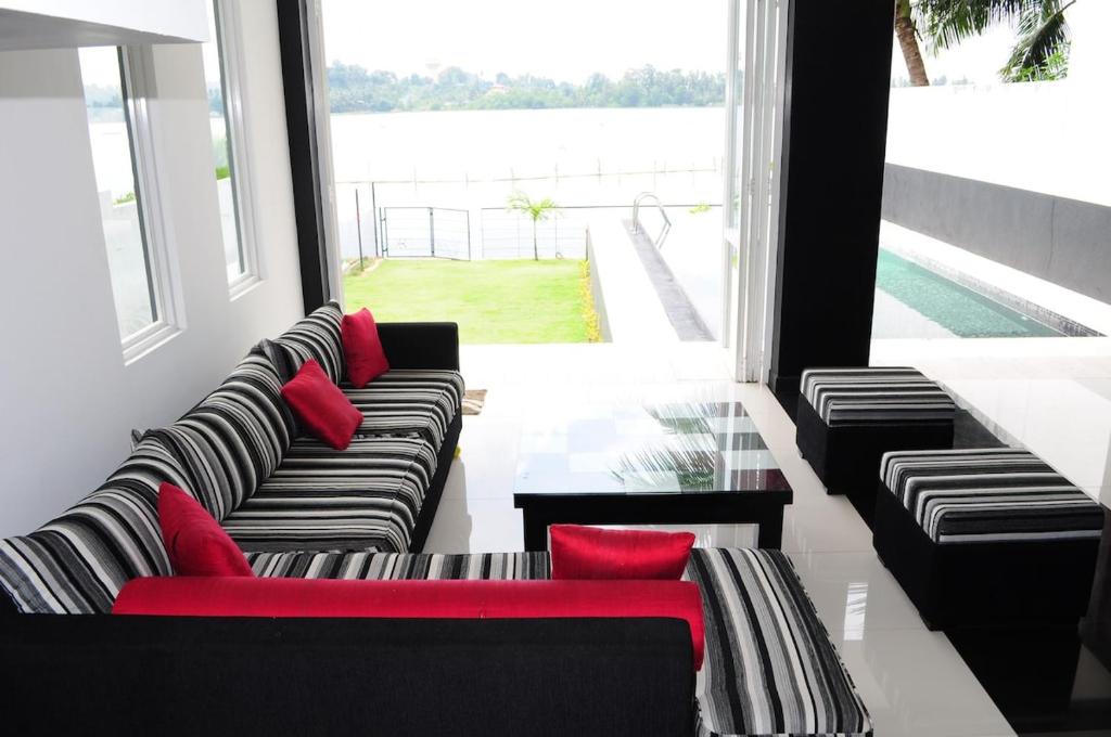 a living room with couches and red pillows at Bolgoda Grand - Luxury by the Lake in Moratuwa
