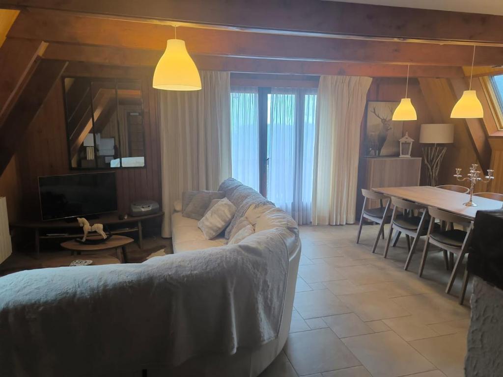 una sala de estar con un sofá y una mesa en Très beau chalet familial, en La Colmiane