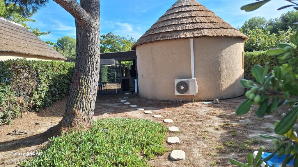 un petit bâtiment avec un arbre et un haut-parleur dans l'établissement Mas bleu île des pêcheurs, au Barcarès