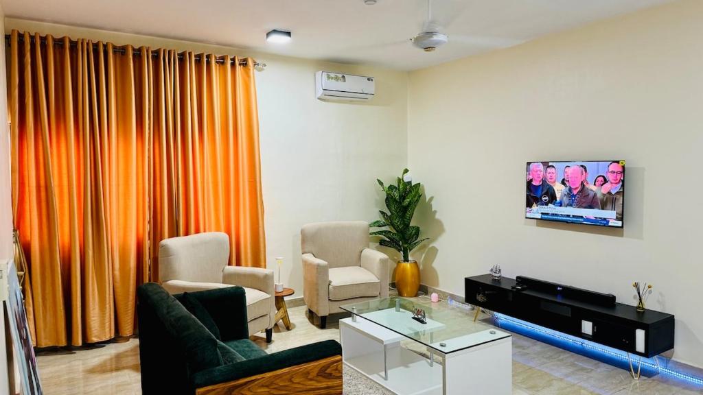 a living room with a couch and a tv at HomeStay in Ikuata
