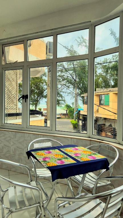 a table with a colorful table cloth on it in front of a window at 2 bedroom Apartment Seaview Flic en Flac in Flic-en-Flac