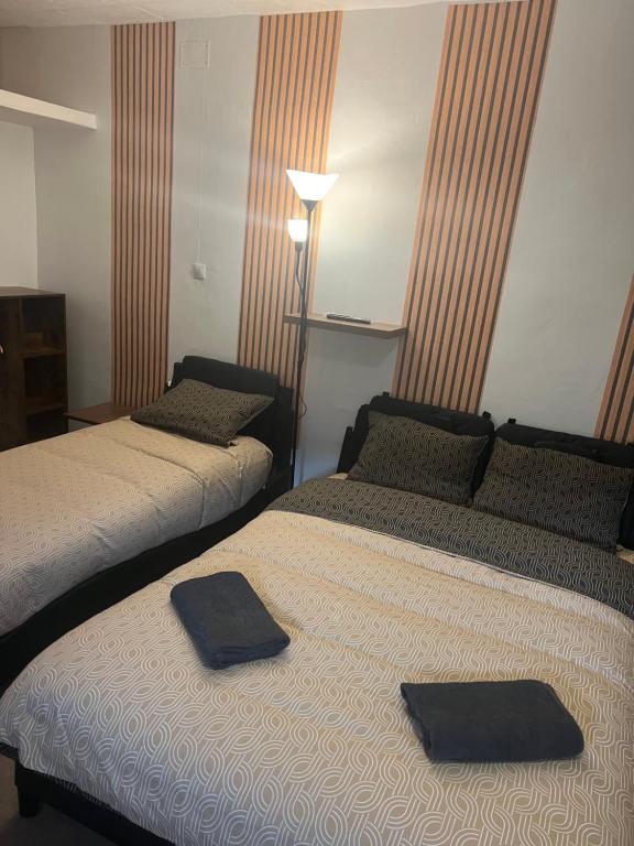 two beds in a hotel room with towels on them at Le Manteau Bleu in Béziers