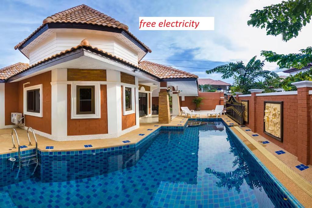 a villa with a swimming pool in front of a house at Villa Marcello in Pattaya South
