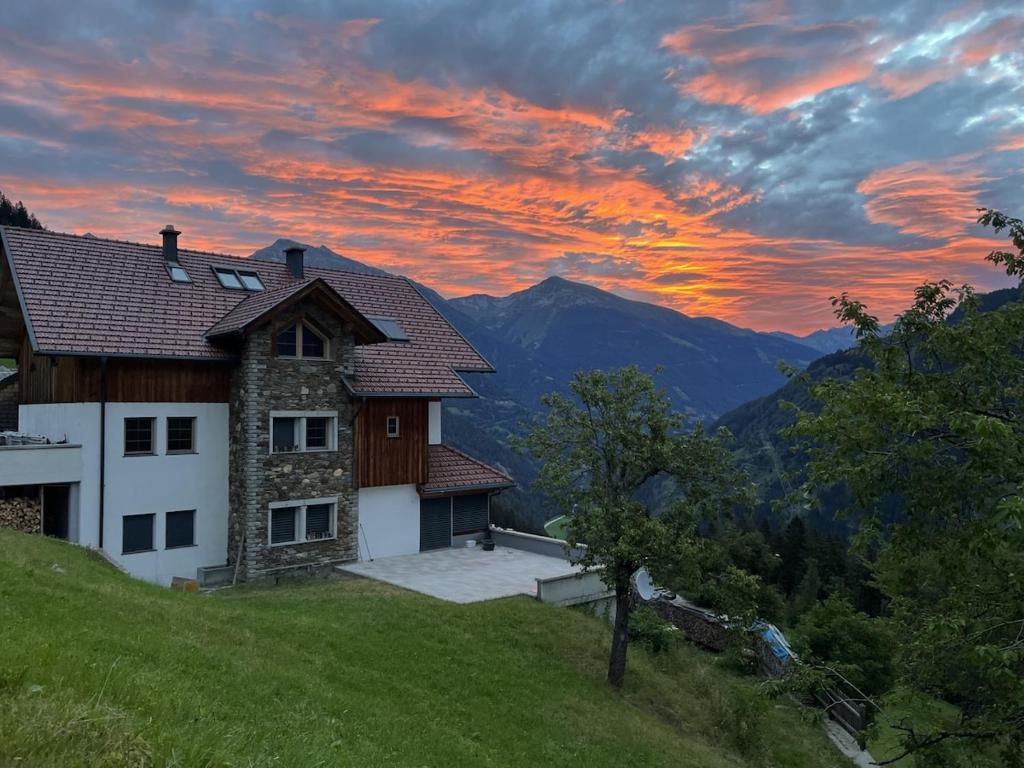 uma casa no topo de uma colina com um pôr-do-sol em Wohnung in den Bergen em Stall
