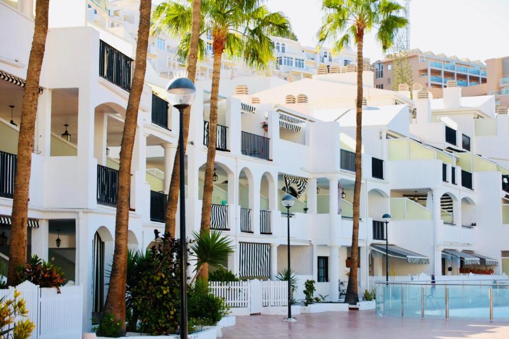 a building with palm trees in front of it at Playa del Cura - Mar Paraiso in Playa del Cura
