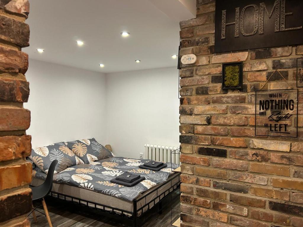 a living room with a couch against a brick wall at Cherry Street Apartment in Wolsztyn
