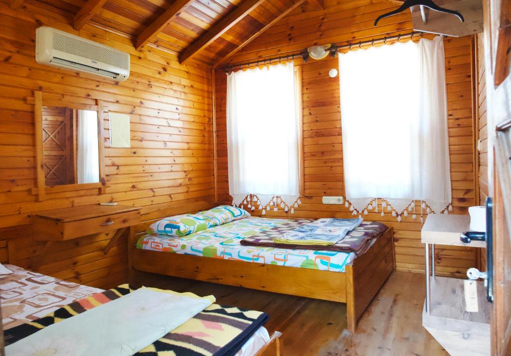 a bedroom with two beds in a wooden cabin at Sheriff, Olympos in Kumluca