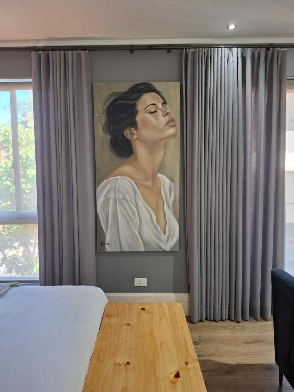 a painting of a woman on a wall in a bedroom at 112 Luxury Studio at The Gallery in Knysna