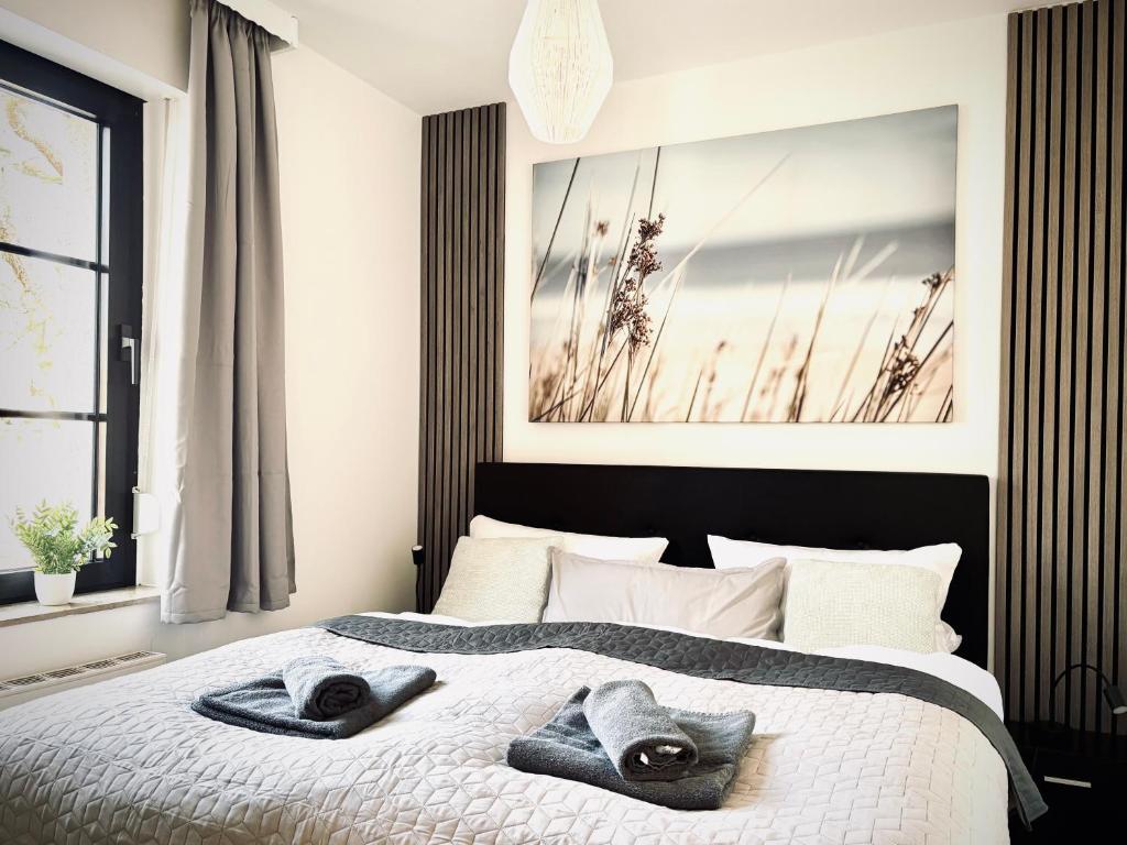 オスナブリュックにあるCity Apartment Osnabrück -- inklusive Parkplatz & WiFi, vollausgestattete Küche mit Geschirrspüler -- Perfekt für Urlaub & Businessのタオルが敷かれたベッドのある寝室