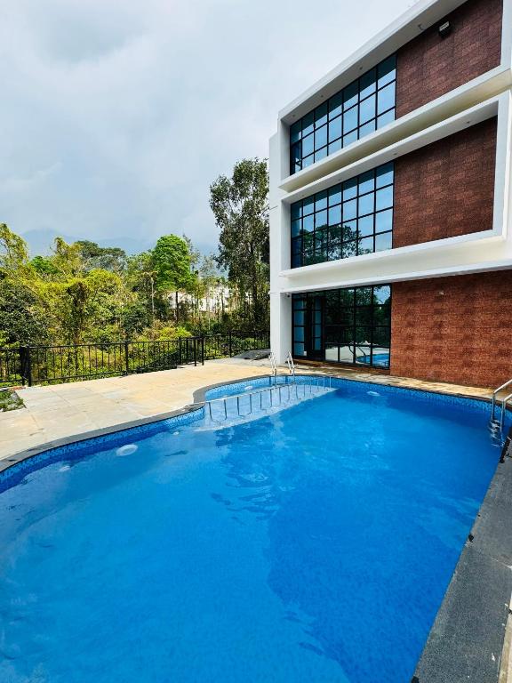 a large swimming pool in front of a building at AYD-IN BY GREENLEAVES Resort in Vythiri