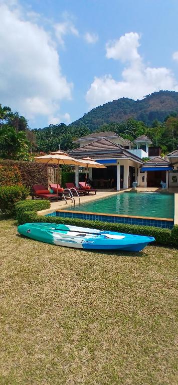 eine Gruppe von Kajaks, die auf dem Gras in der Nähe eines Hauses sitzen in der Unterkunft OMG !! Amazing Sea Views !! Stunning Sunsets !! Khao Thong Krabi Thailand in Ban Khao Thong