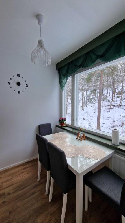 a dining room with a table and chairs and a window at Rentoudu Tässä in Lahti