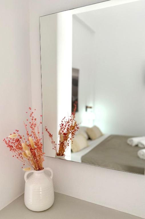 a white vase sitting on a counter in front of a mirror at Giasemi Fira Studios in Fira