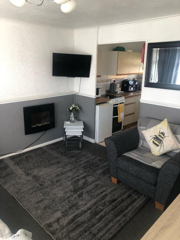 a living room with a couch and a fireplace at 2 Bedroom Chalet Close to Beach in Hemsby