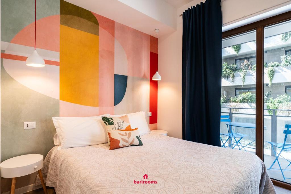 una camera con letto e parete colorata di BARIROOMS - Melo Suites a Bari