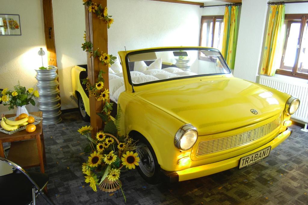 a yellow car parked in a room with flowers at Landhaus Sorgenfrei in Hohnstein