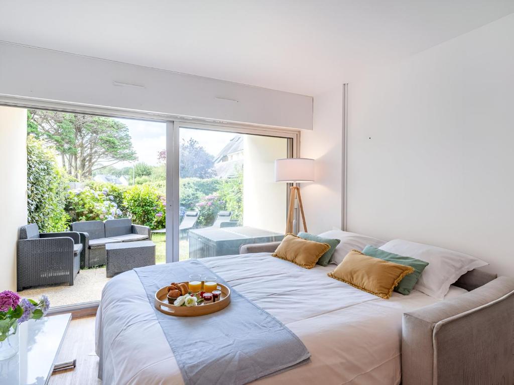 - une chambre avec un grand lit et une corbeille de fruits dans l'établissement Charmant studio jardin bord de mer Carnac-Plage, à Carnac