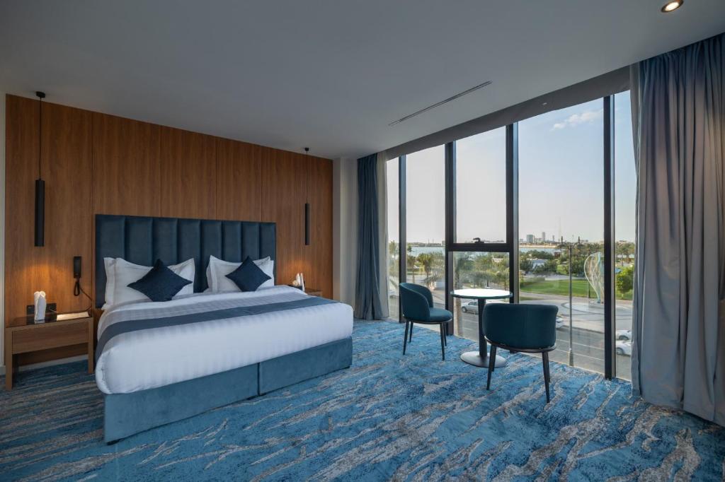 a hotel room with a bed and a table and chairs at Nasim Azraq Hotel in Jeddah